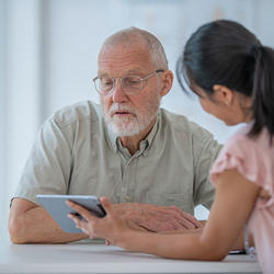 Male patient with nurse looking at a tablet