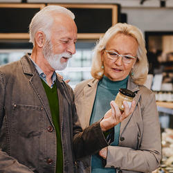A couple reading the ingredient list of a product at a grocery store 