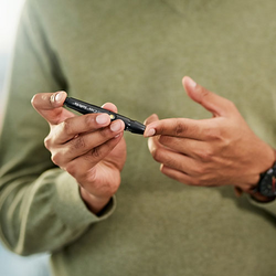 Person checking their blood glucose levels using a finger pricker
