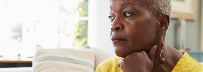 Lady sitting down looking to the side deep in thought