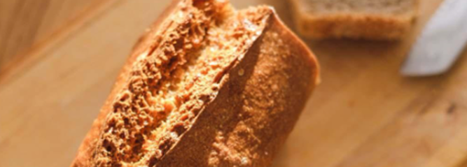 Fresh loaf of bread sliced on a chopping board